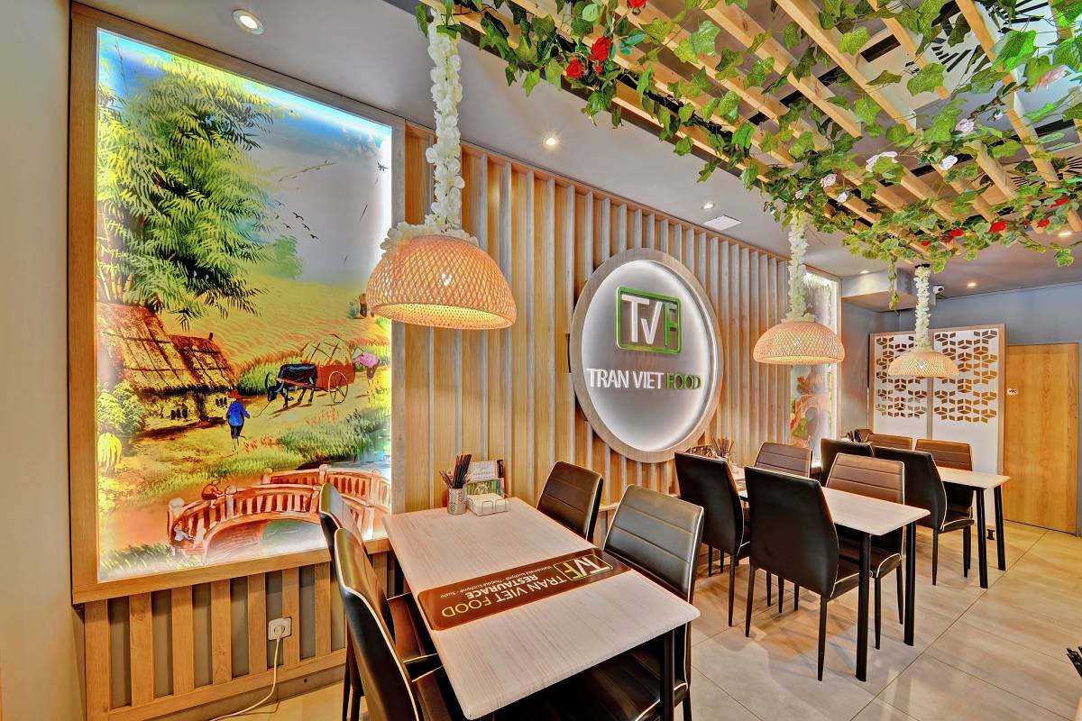 Interiér Tran Viet Food s podsvícenou malbou vietnamské krajiny